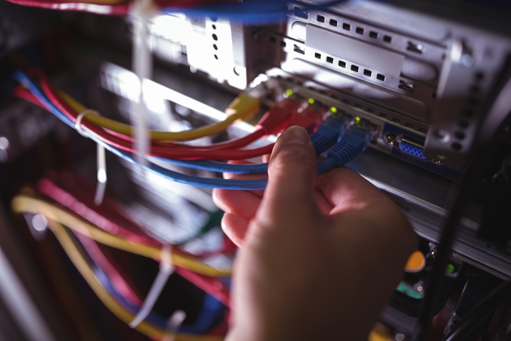 Close-Up of technician plugging patch cable in a rack mounted server in server room.jpeg